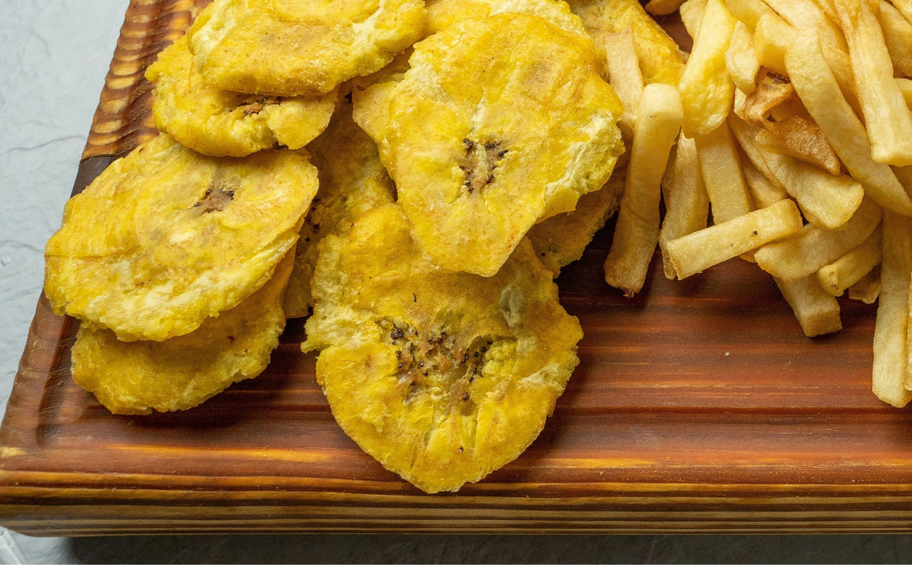Crispy Puerto Rican tostones on a wooden board — twice-fried green plantains
